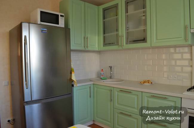 Серебристый холодильник на светло-зеленой кухне