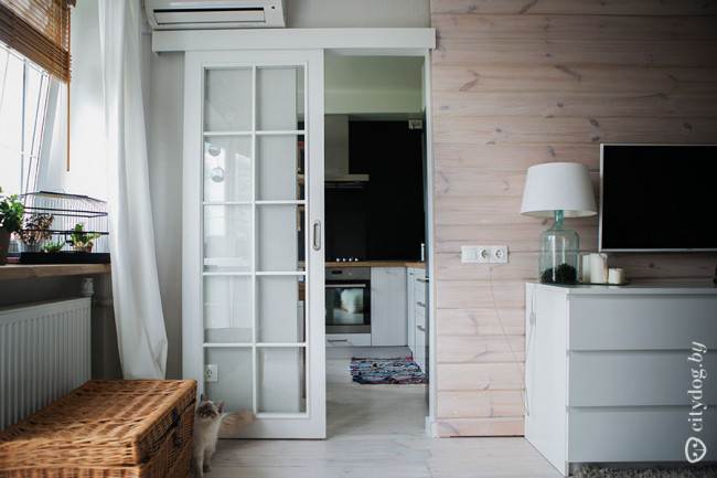 Белая раздвижная дверь лаконичной формы на кухне