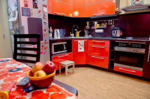 Современная оранжевая кухня  12 кв.м с черным фартуком (13 фото)