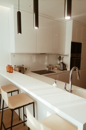 Современная белая кухня без ручек. Барная стойка с интегрированной мойкой