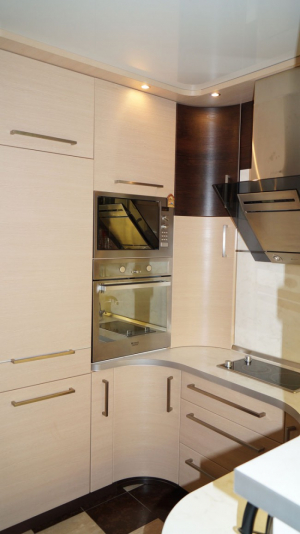 П-образная бежевая кухня 10 кв. с барной стойкой и белым диваном