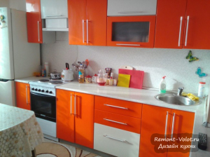 Оранжевая кухня 12 кв. м с телевизором и диваном