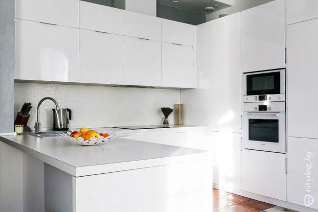 Дизайн П-образного гарнитура белого цвета на 10 кв. м в просторной кухне-гостиной